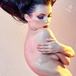 Nude Art Woman With Hair In The Form Of Horns A Female Demon With Bright Makeup Perfect Body Girl The Horns On The Head. Devil In Feminine Guise Halloween. Hairstyle Hair Brunette