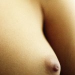 Womans bare breast close-up.